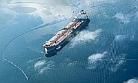 Exxon Valdez tanker circled with containment boom